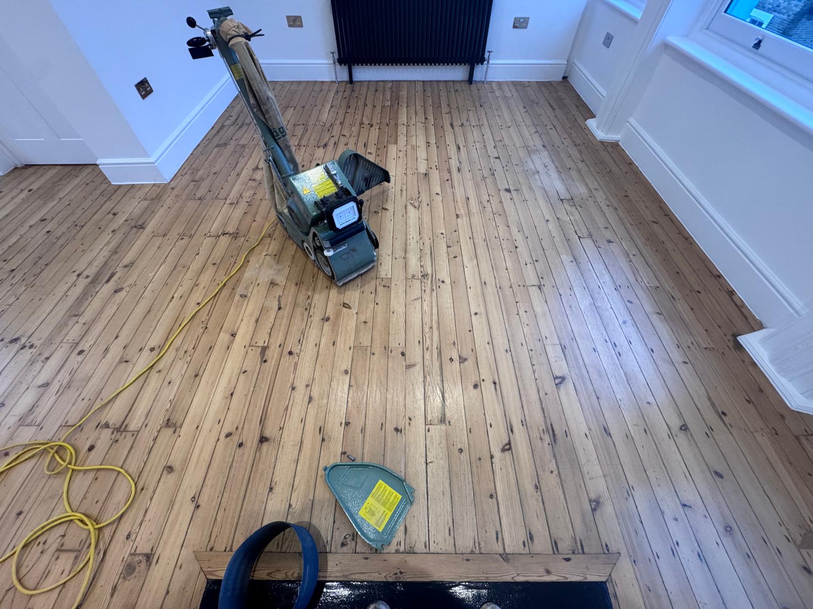 Wood Floor Sanding in Brockley for Original Pine Floorboards Wood Floor Sanding in Brockley on original pine floorboards with a professional sanding machine in a bright residential room